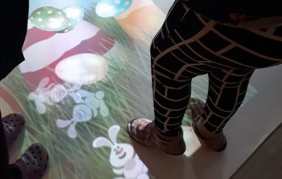 Kuvassa yksikön taikalattia, jonka päällä kaksi henkilöä seisoo. Heinkilöistä näkyy kuvassa vain jalat. Lattia on värikäs ja siinä on muun muassa pupun kuvia.
