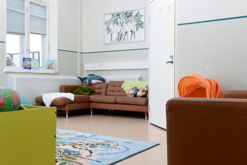 Juniori-Martin olohuone, jossa ruskeita nahkasohvia ja niiden päällä värikkäitä tyynyjä ja tekstiilejä. Lattialla vaaleansininen matto, jossa kartta.