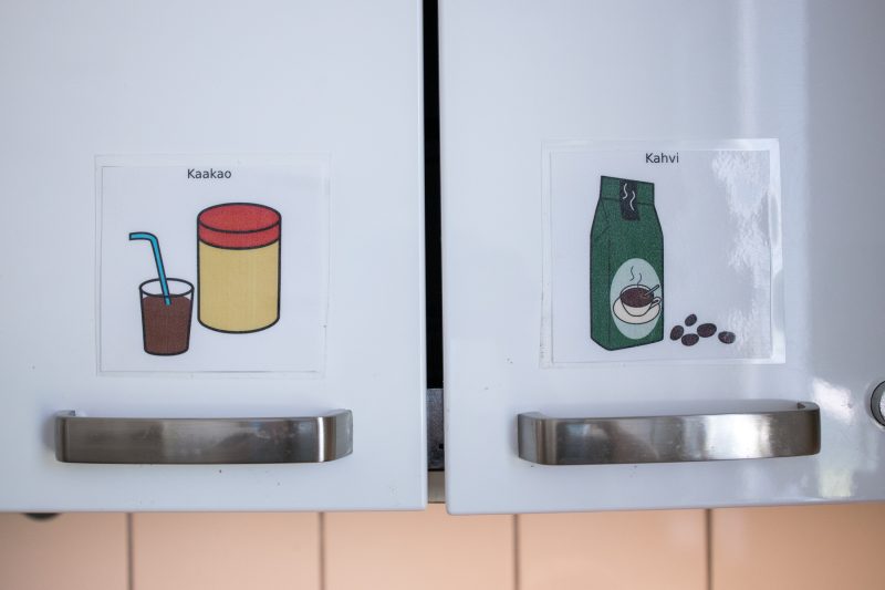 Kuvassa lähikuva kaapin ovista, joissa on kuvilla kerrottu mitä kaapeista löytyy: kaakaota ja kahvia.