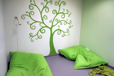 Toimintakeskus Kipparin leponurkka, jossa on kaksi vihreää Fatboy-säkkituolia lattialla. Valkoisessa seinässä on vihreä puun kuva ja toinen seinä on vaalean vihreä.