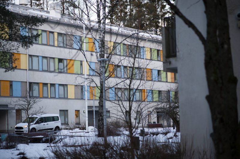 Ulkokuva Kuninkaankallion rakennuksesta. Rakennus on neljäkerroksinen ja ikkunoiden väliset tilat on maalattu eriväreillä. Maassa on lunta.