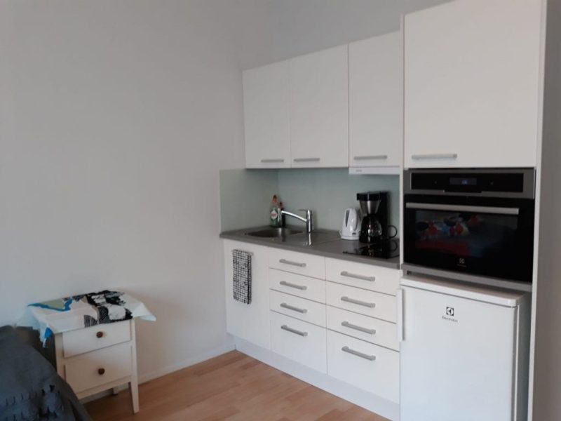 Kuva Niittypellon asuinhuoneesta. Kuvassa näkyy valkoinen keittiö, joka on varusteltu peruskodinkonein.
