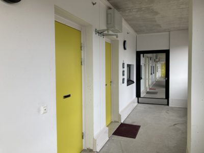 Käytäväkuva Saunalahden tukiasunnoista. Seinät ovat valkoiset ja ovet keltaisia.