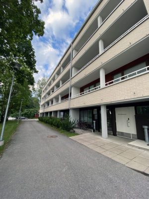 Ulkokuva Suntionpolusta. Rakennus on nelikerroksinen ja vaaleaa tiiltä. Pihapiiri on vehreä.