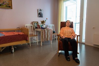 Nainen istuu keinutuolissa.