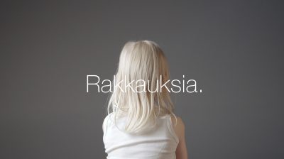 Vaaleahiuksinen lapsi kuvattuna takaapäin, keskellä teksti Rakkauksia.