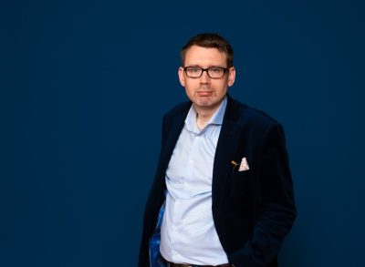 Mies katsoo kameraan.