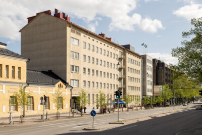 Kuva kadusta, jonka varrella erikokoisia kerrostaloja.