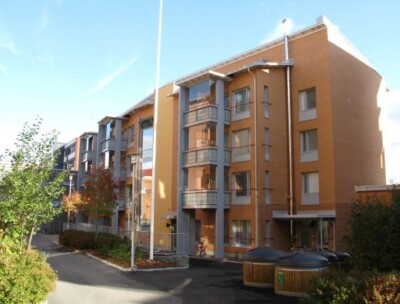 Vaalenaruskea kerrostalo.