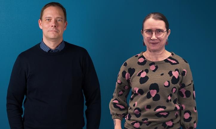 Mies ja nainen seisovat rinnakkain katsoen kameraan.