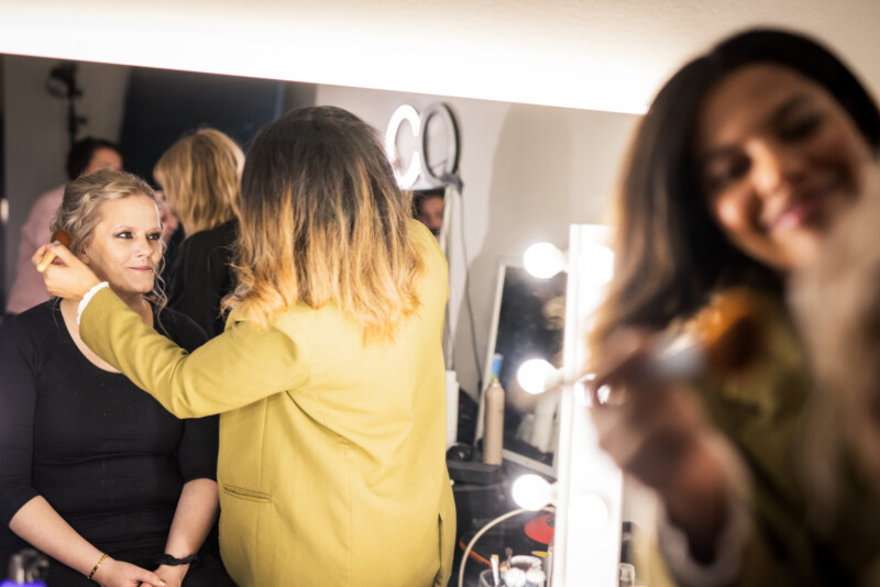 Meikkaaja ja kampaaja työssään.