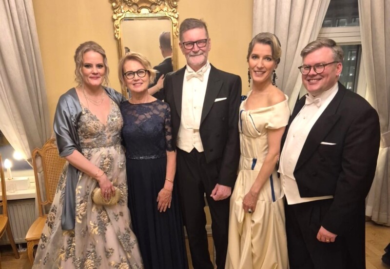 Joukko ihmisiä seisoo rivissä juhlavaatteissa presidentin linnassa.