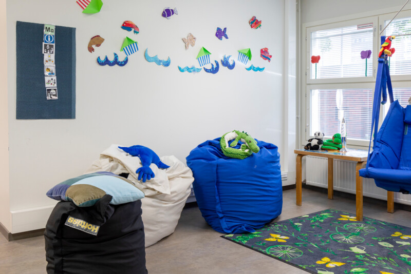 Huone, jossa erivärisiä säkkituoleja lattialla, seinällä meriteemaisia kuvia.