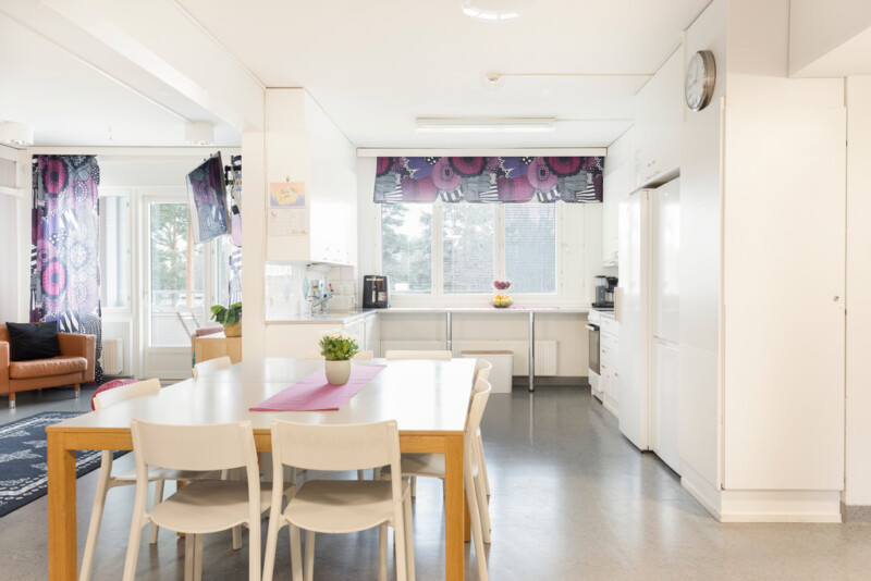 Keittiön edustalla kahdeksan hengen ruokapöytä tuolineen.